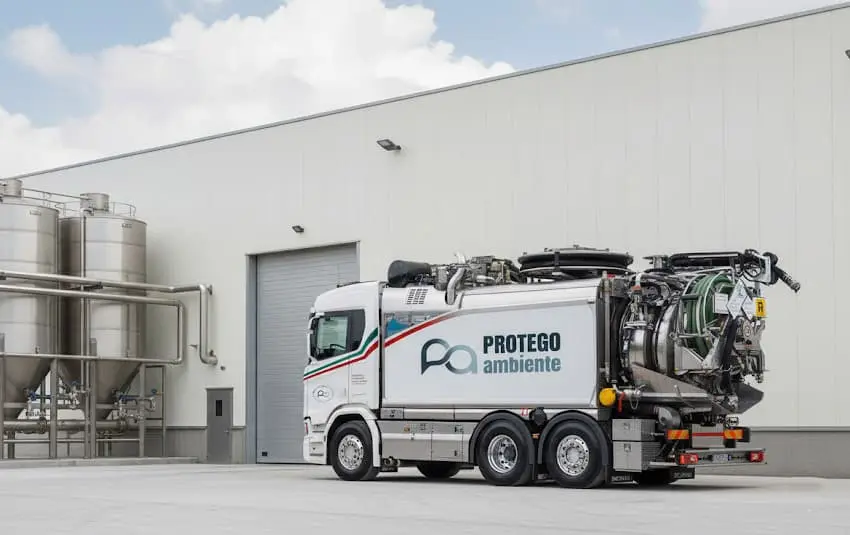 Camion attrezzato Protego Ambiente davanti a uno stabilimento con silos in acciaio